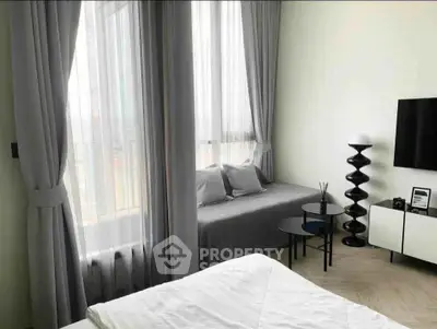 Modern bedroom with stylish decor and large windows offering natural light.