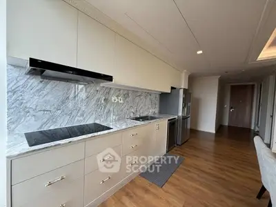 Modern kitchen with sleek cabinetry and marble backsplash in a stylish apartment.