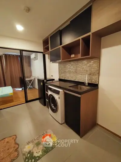 Modern compact kitchen with washing machine and sleek cabinetry