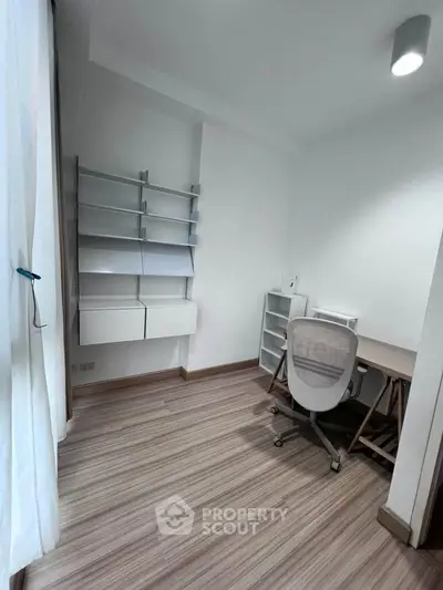 Modern study room with sleek desk and shelving, perfect for productivity.