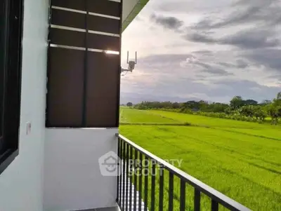 Charming balcony with serene countryside view, perfect for relaxation and enjoying nature.
