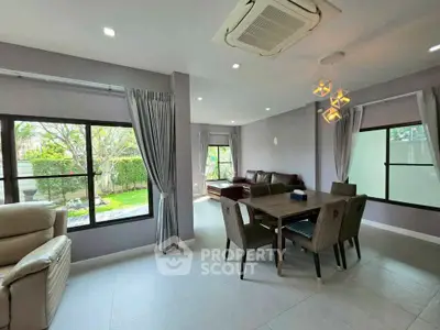 Spacious living room with garden view, modern furniture, and elegant lighting in a stylish home.