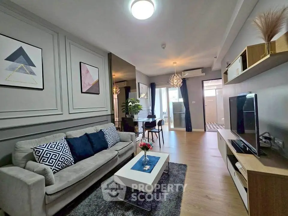 Modern living room with stylish decor and open layout, featuring a cozy sofa and sleek entertainment center.