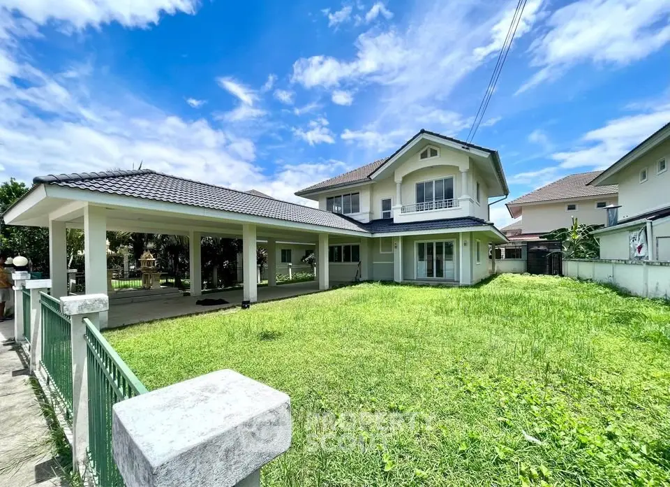 Spacious two-story house with lush green lawn and covered carport in a serene neighborhood.
