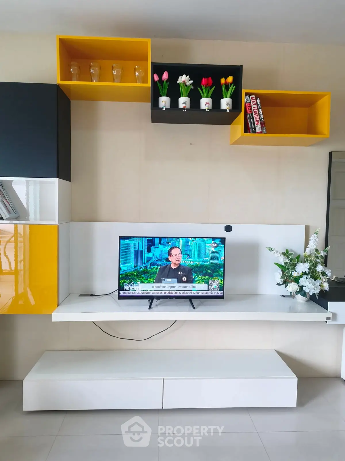 Modern living room with stylish TV unit and vibrant wall shelves