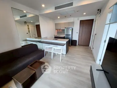 Modern open-layout living room with sleek kitchen and stylish furniture
