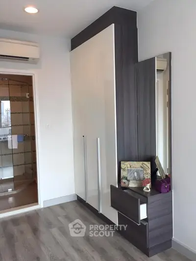 Modern bedroom with sleek wardrobe and stylish decor in a contemporary apartment.