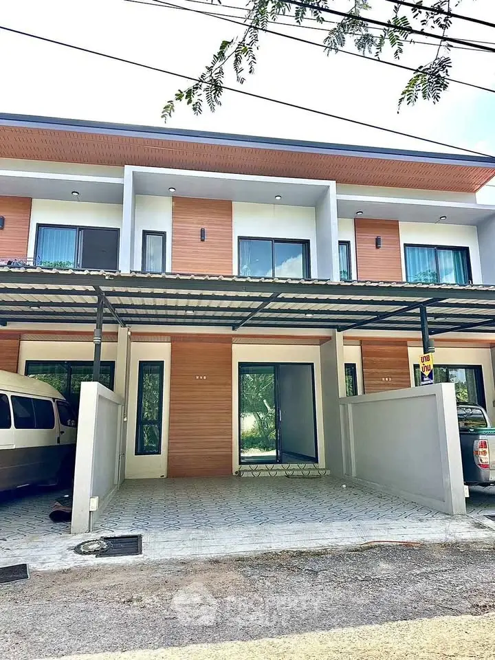 Modern townhouse exterior with carport and sleek design in a suburban setting.