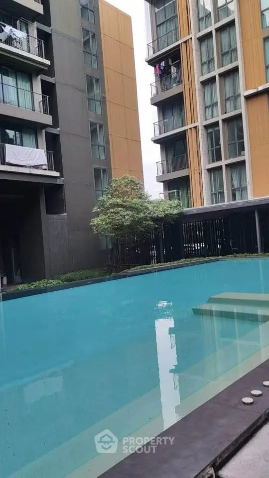 Modern apartment complex with a stunning pool and lush greenery