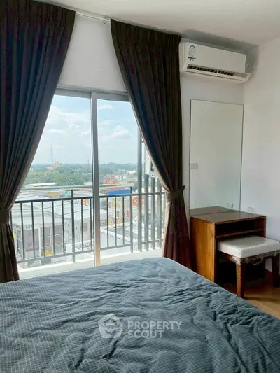 Modern bedroom with balcony and stunning city view, featuring elegant curtains and air conditioning.