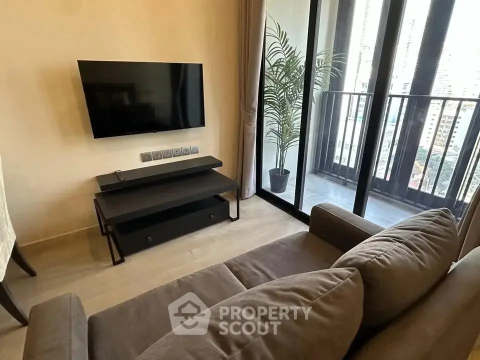 Modern living room with balcony view and wall-mounted TV in urban apartment.