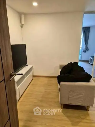 Cozy living room with modern TV setup and wooden flooring