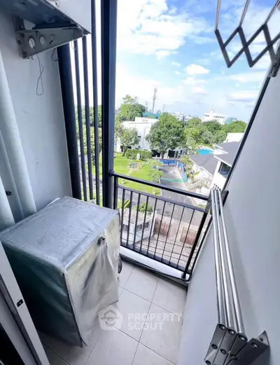 Charming balcony with scenic view and laundry area in modern apartment.