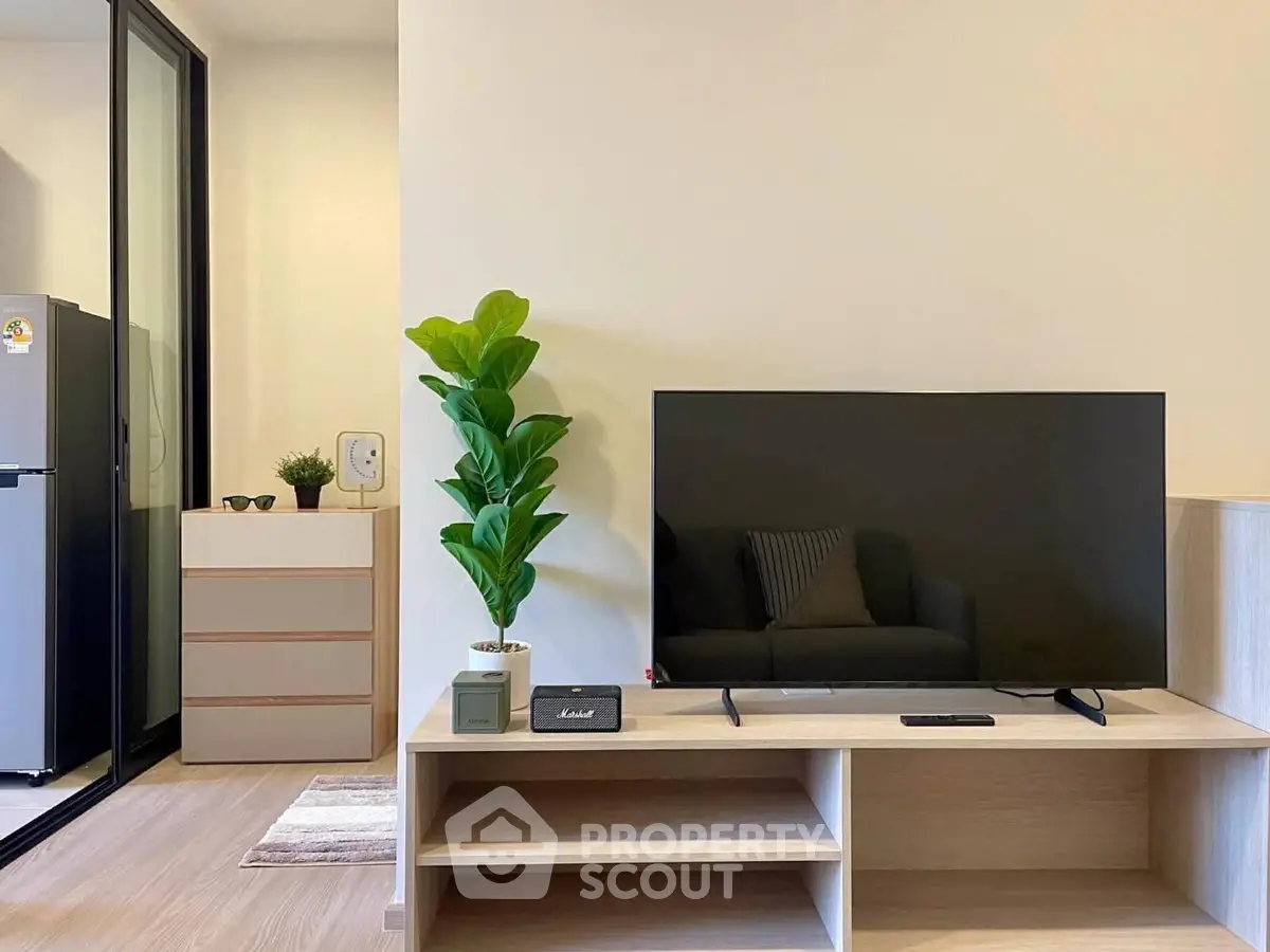 Modern living room with sleek TV setup and stylish decor in a contemporary apartment.