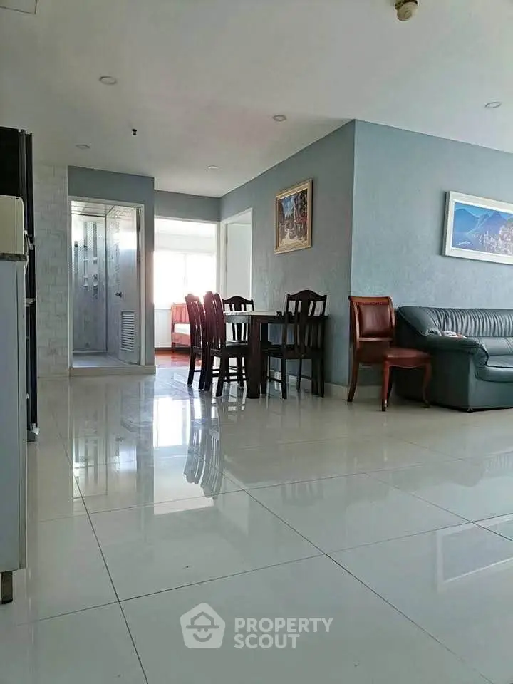 Spacious living room with glossy tiled floors and elegant dining area in modern apartment.