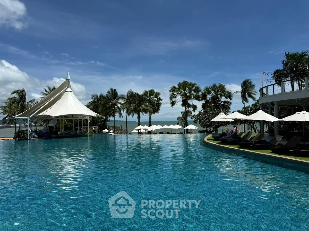 Luxurious resort pool with ocean view and palm trees, perfect for relaxation and leisure.