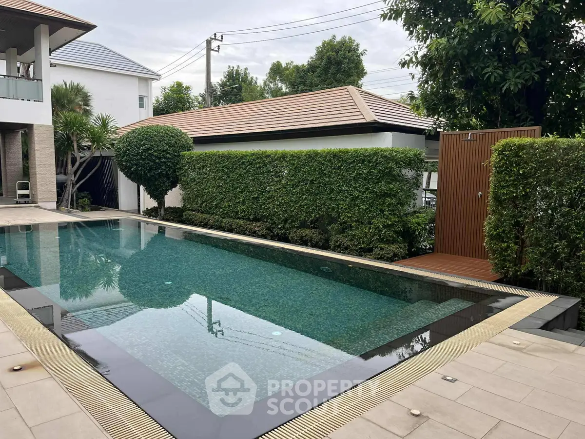 Luxurious outdoor pool area with lush greenery and modern design, perfect for relaxation and leisure.