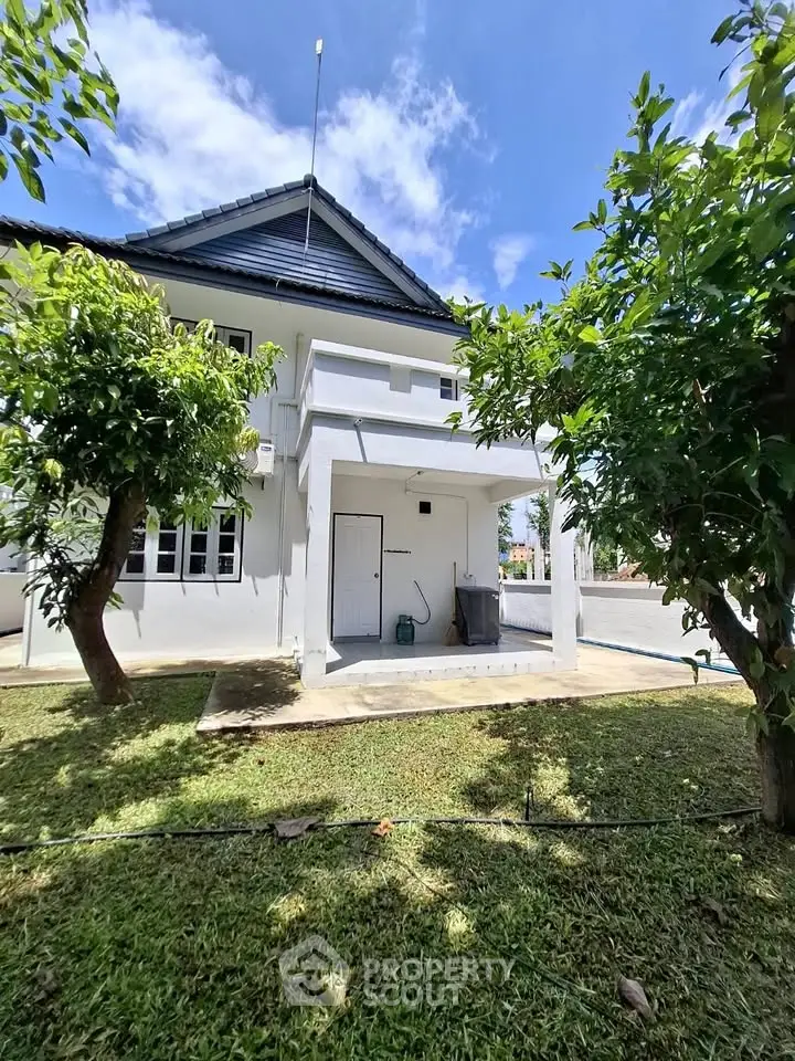 Charming two-story house with lush garden and spacious outdoor area, perfect for family living.