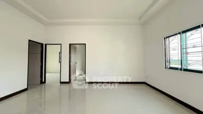 Spacious empty room with tiled flooring and large window, perfect for customization.