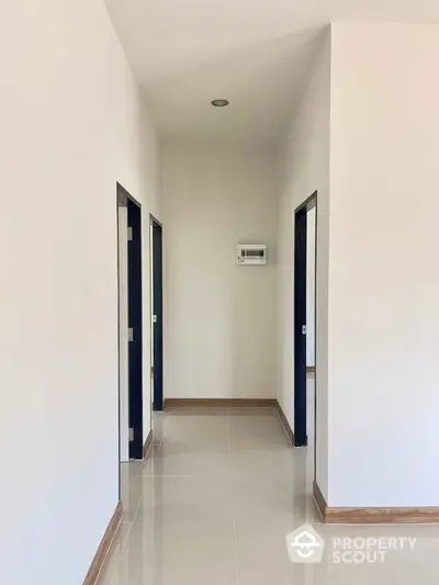 Modern minimalist hallway with sleek tile flooring and neutral walls