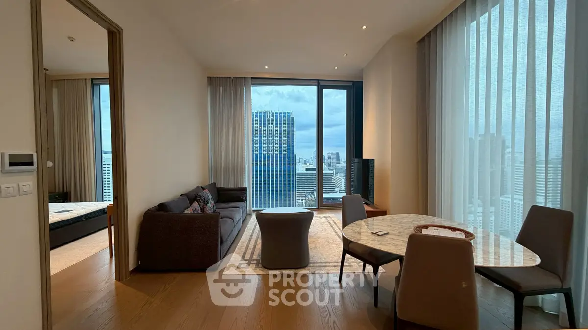 Modern living room with city view, featuring elegant furniture and large windows for natural light.