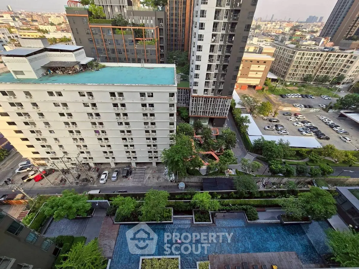 Stunning aerial view of modern urban residential complex with lush greenery and pool area.
