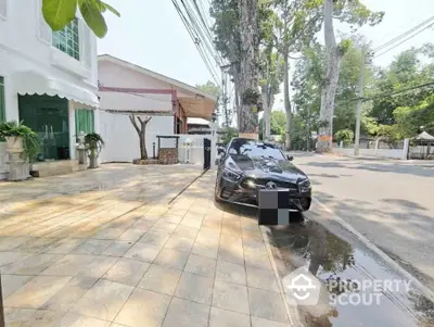 Charming street view with elegant building and parked luxury car, perfect for urban living.