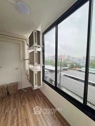 Spacious balcony with large windows offering a panoramic city view, perfect for relaxation and enjoying the outdoors.