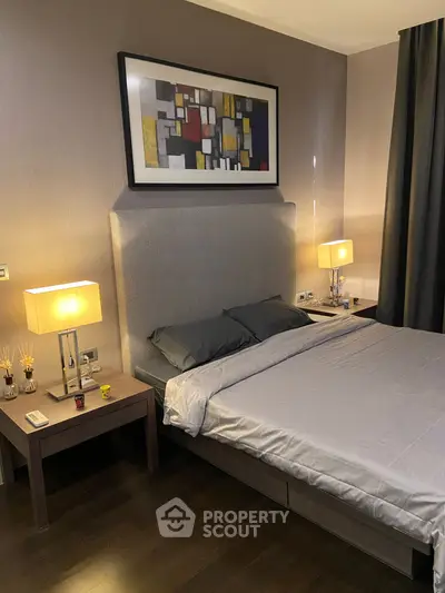 Elegant bedroom with modern decor and ambient lighting, featuring a stylish headboard and contemporary artwork.