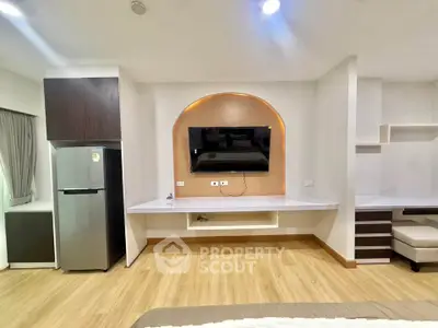 Modern living room with built-in TV unit and sleek refrigerator