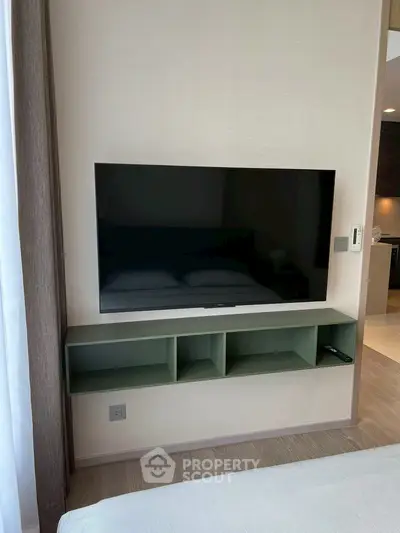 Modern bedroom with wall-mounted TV and sleek storage unit