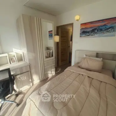 Cozy bedroom with modern furniture and scenic artwork, perfect for relaxation and comfort.