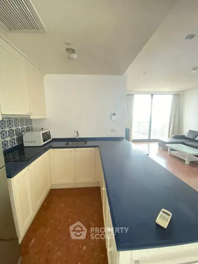 Modern open kitchen with blue countertops and spacious living area