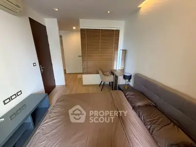 Modern bedroom with stylish decor and natural light, featuring a cozy bed and sleek furniture.