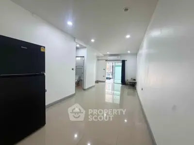 Spacious modern apartment interior with sleek flooring and ample natural light.