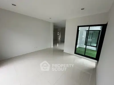 Spacious modern interior with sleek tile flooring and large windows for natural light.