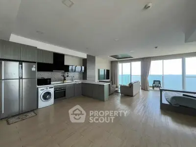 Spacious open-plan living area with ocean view, modern kitchen, and cozy seating.