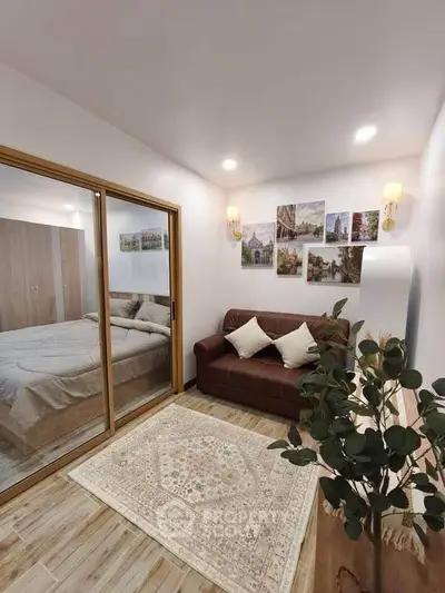 Cozy living room with elegant decor and a view into a stylish bedroom through sliding glass doors.
