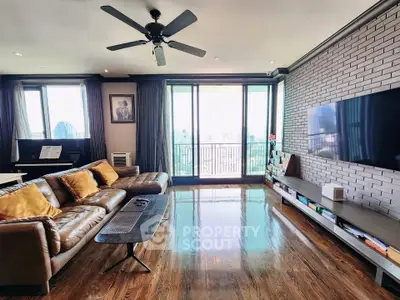 Spacious living room with modern decor and city view balcony access.