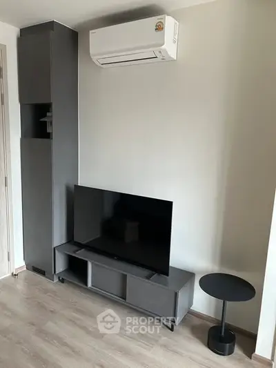 Modern living room with sleek TV setup and air conditioning unit.