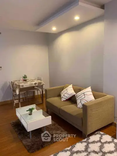 Cozy living room with modern sofa and dining area, perfect for relaxation and entertaining.