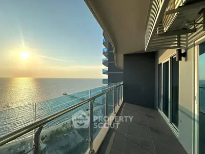 Stunning ocean view from a spacious modern balcony at sunset.