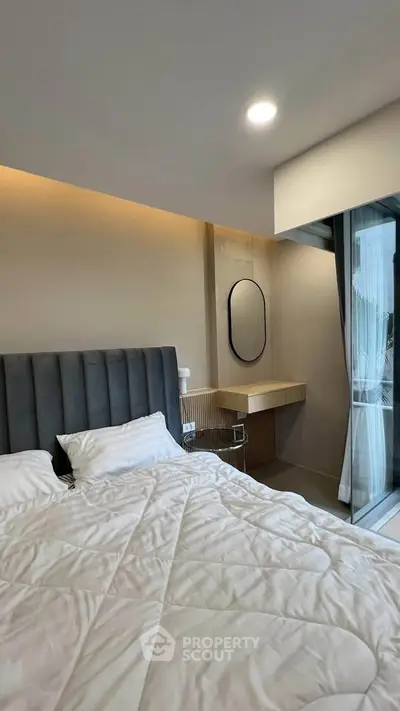 Modern bedroom with sleek design and large window for natural light.