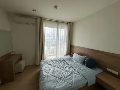 Modern bedroom with large window and stylish wooden furniture