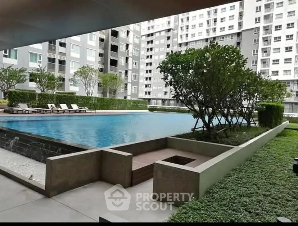 Luxurious condominium pool area with lush greenery and modern design.