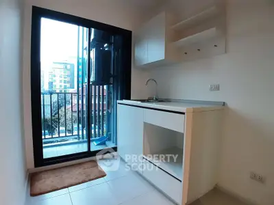 Compact kitchen with balcony view in modern apartment