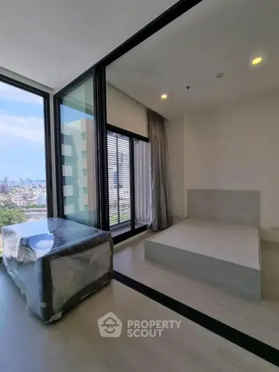 Modern bedroom with large windows and city view in high-rise apartment