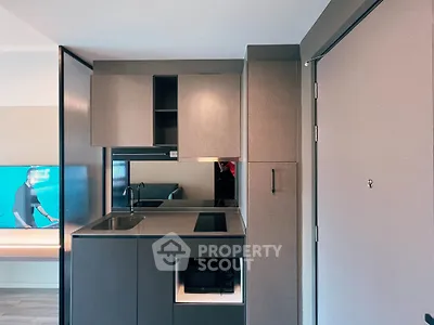 Modern compact kitchen with sleek cabinetry and built-in appliances in a stylish apartment.