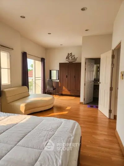 Spacious bedroom with elegant wooden flooring and natural light
