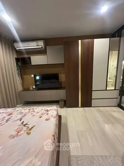 Modern bedroom with stylish wardrobe and floral bedding in a cozy apartment.
